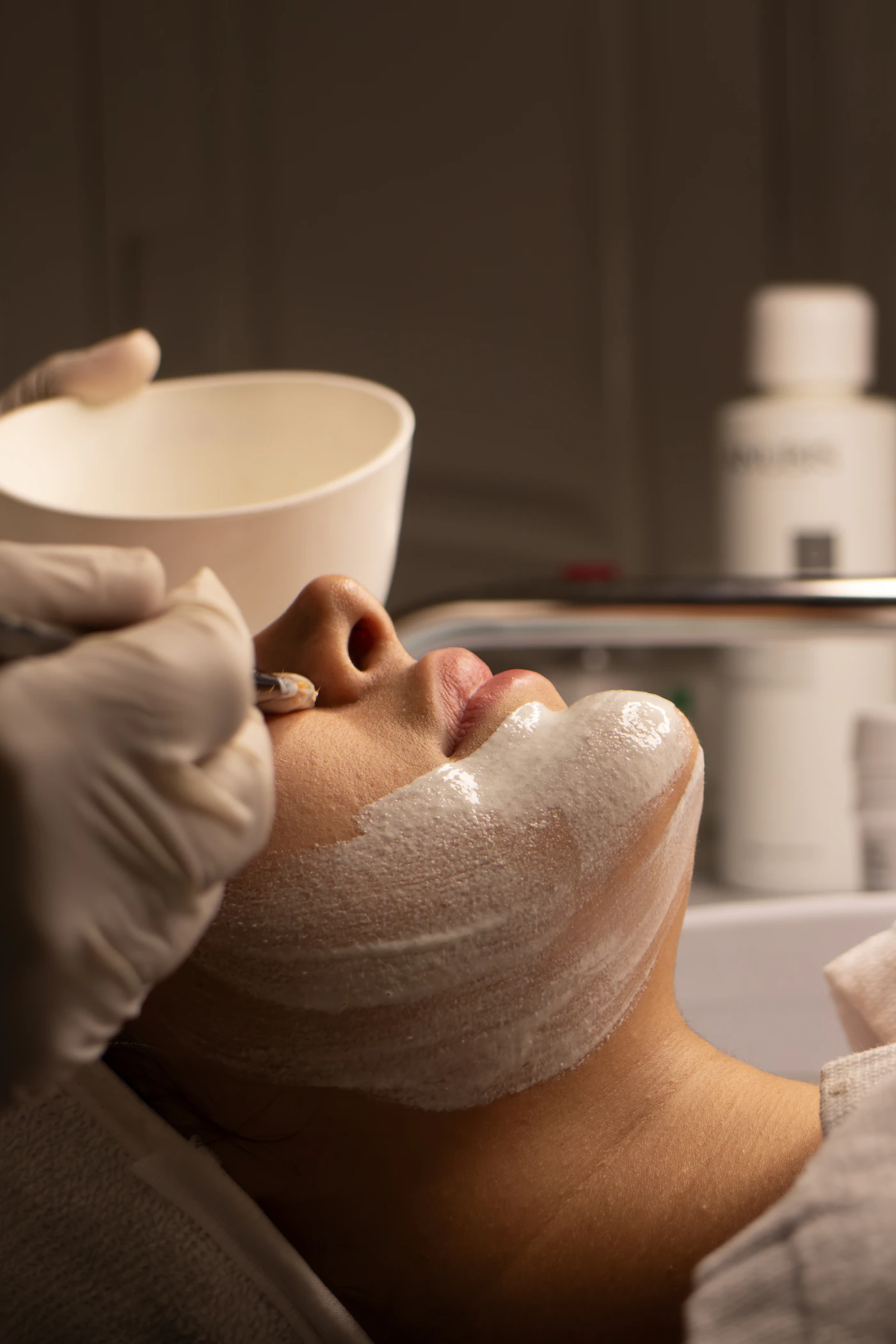 Profesional aplicando crema facial a una paciente